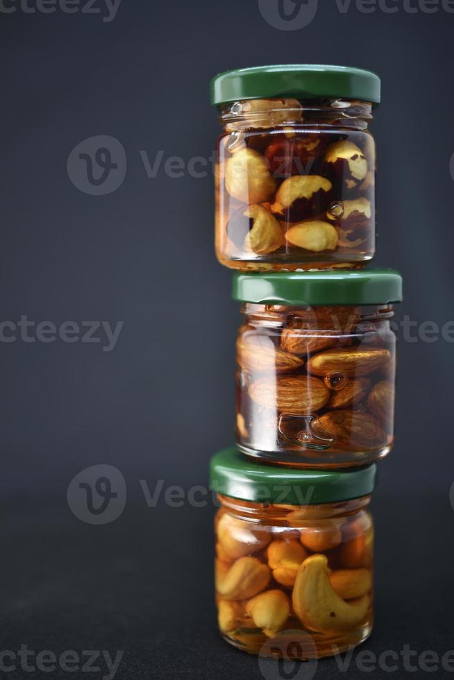 Glass jars with nuts in honey. Delicious sweets. Nuts in honey. Sweet nuts. photo