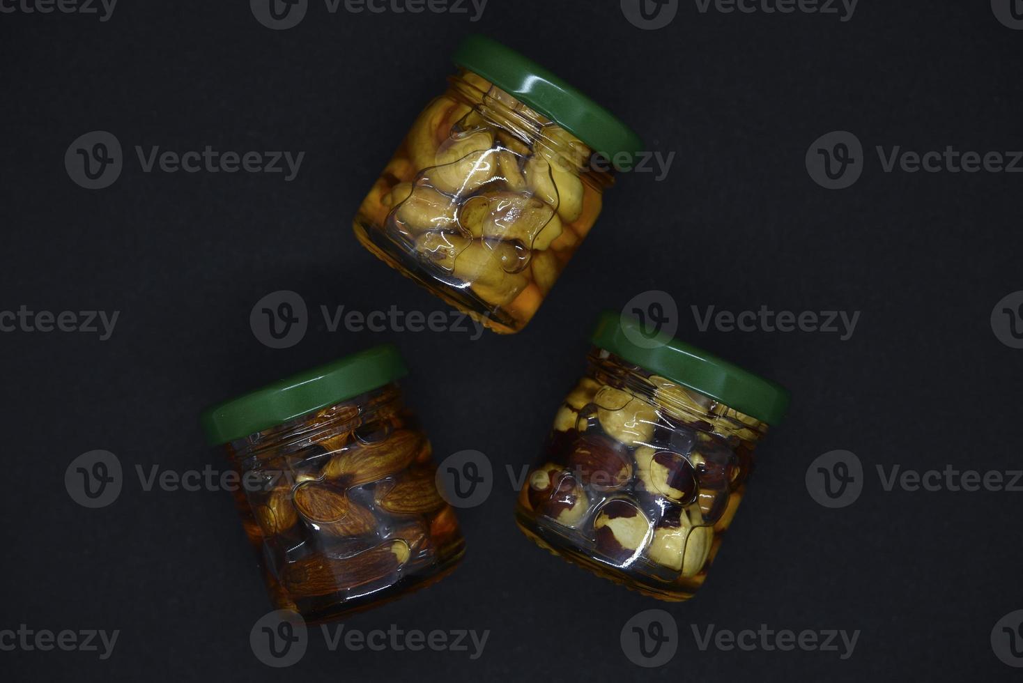 Glass jars with nuts in honey. Delicious sweets. Nuts in honey. Sweet nuts. photo