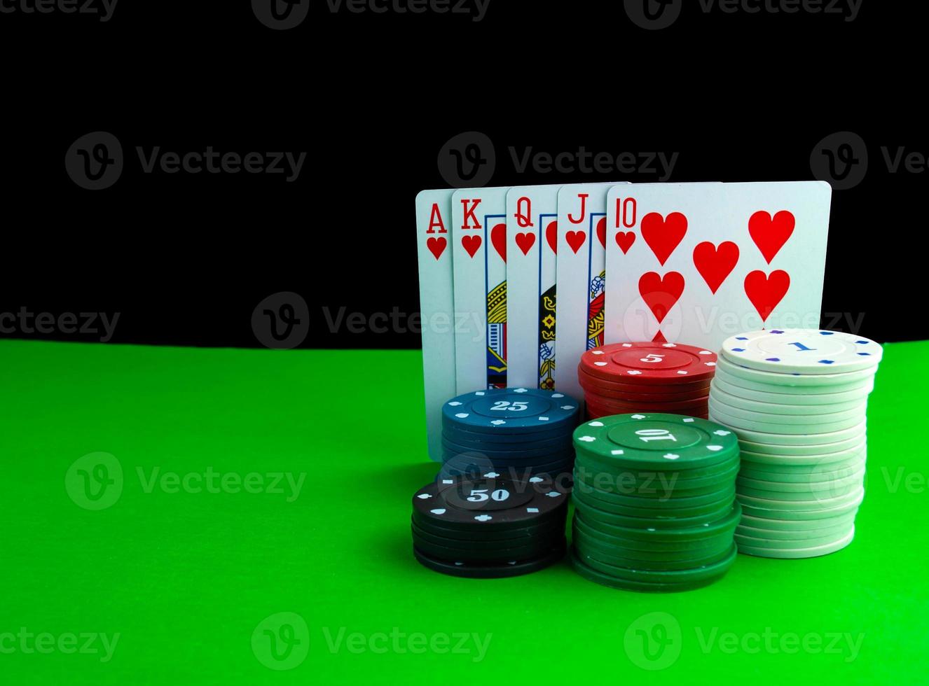 Royal flush cards and poker chips in stacks on the poker table. photo