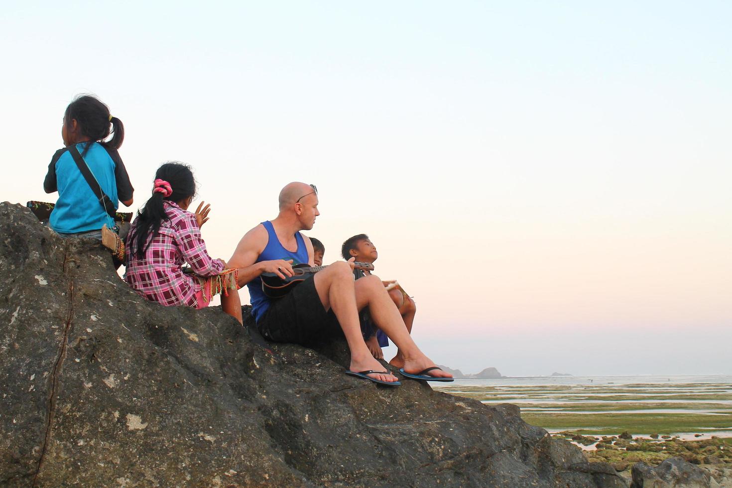 Lombok, Indonesia - August, 2014. tourists and local children playing together on the beach photo