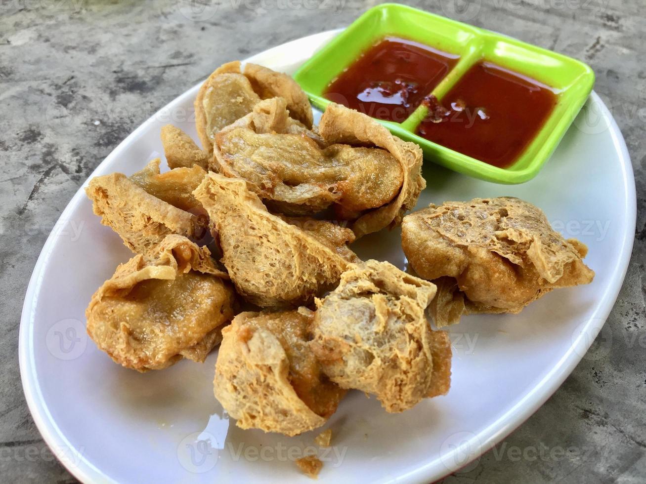 A plate of fried dumplings with sauces and a green plate with the word fried on it. photo