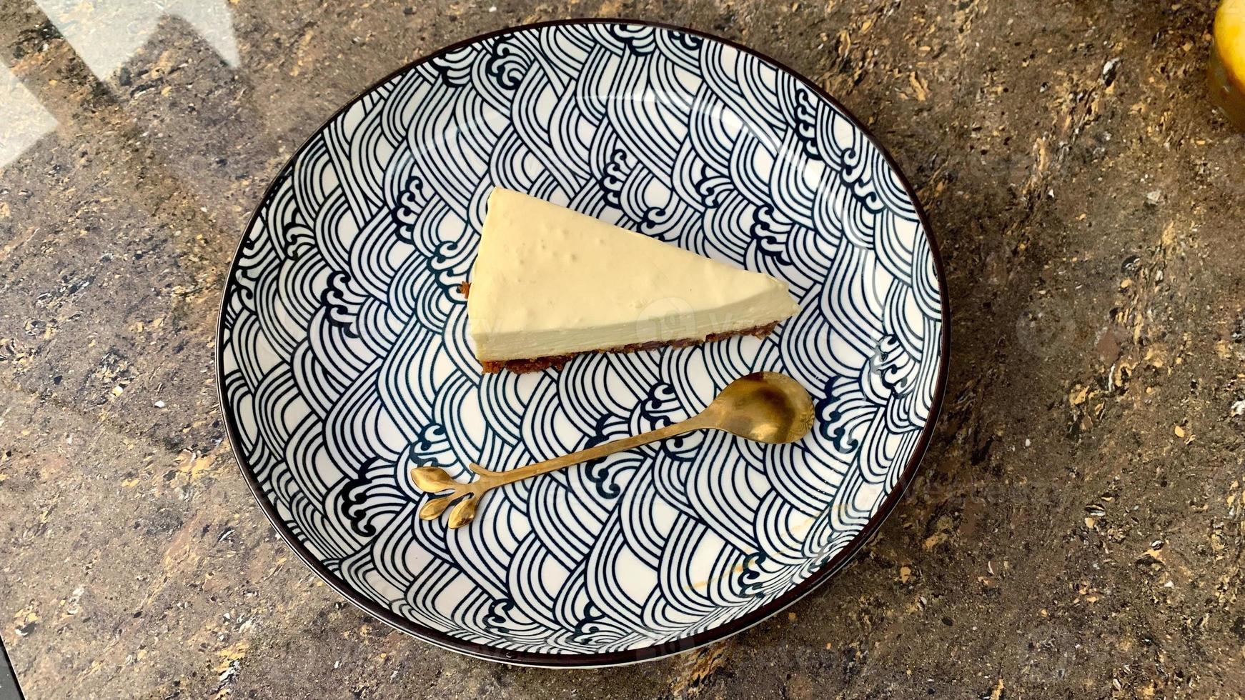 Slice of cheese cake on a plate with beautiful pattern photo