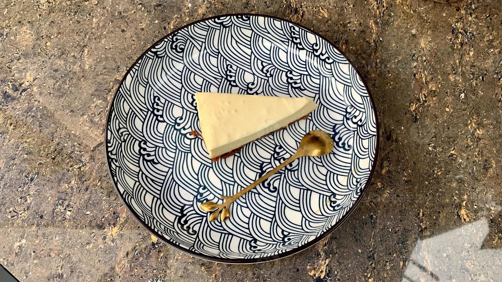 Slice of cheese cake on a plate with beautiful pattern photo