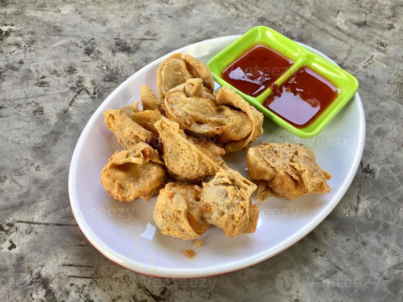 A plate of fried dumplings with sauces and a green plate with the word fried on it. photo