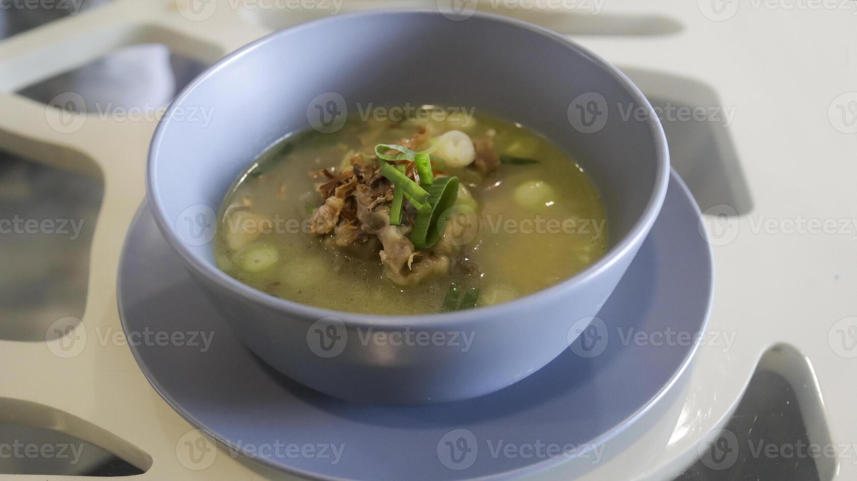 Oxtail soup is a soup made with beef tails served in a table photo