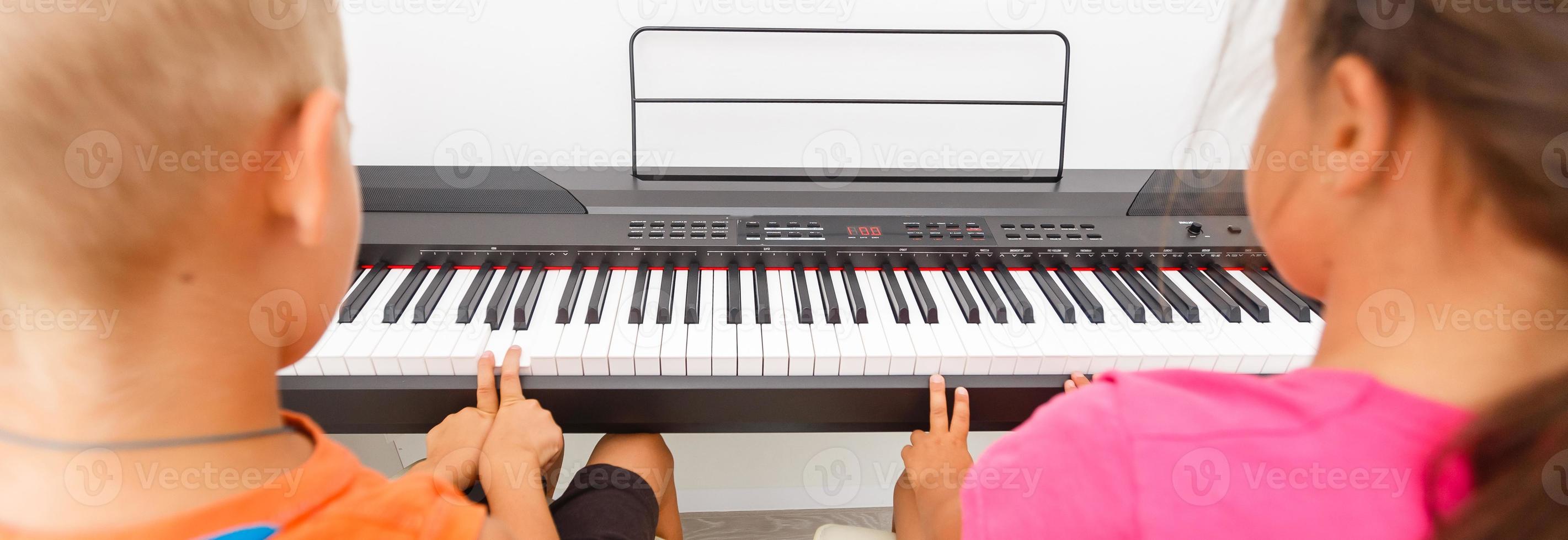 Brother And Sister Playing Piano photo