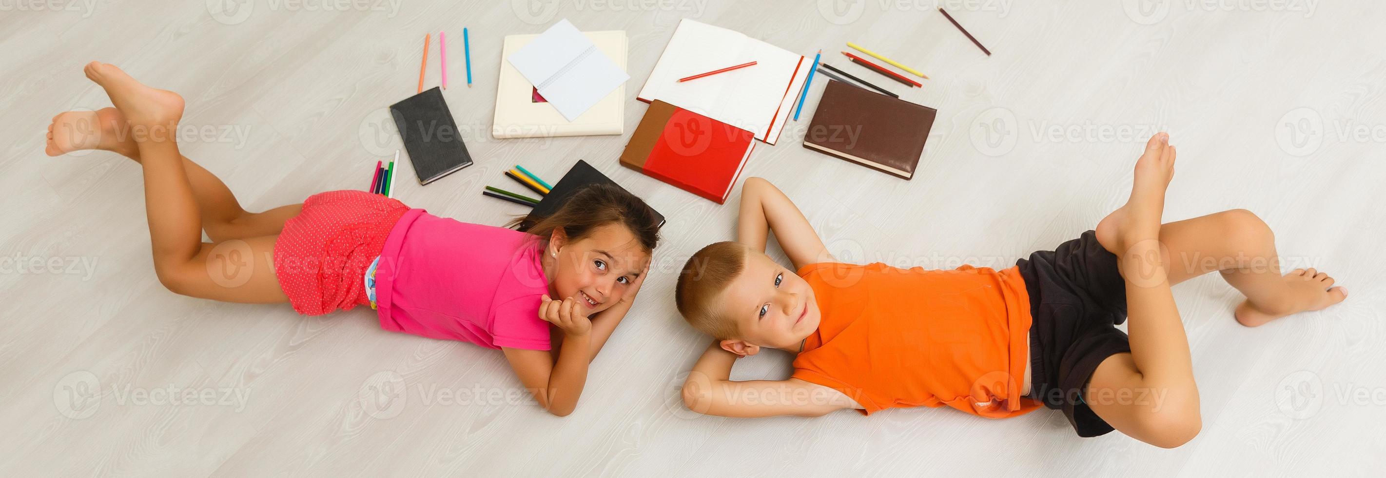 Two children, little girls of preschool age watching tablet at home on the floor photo