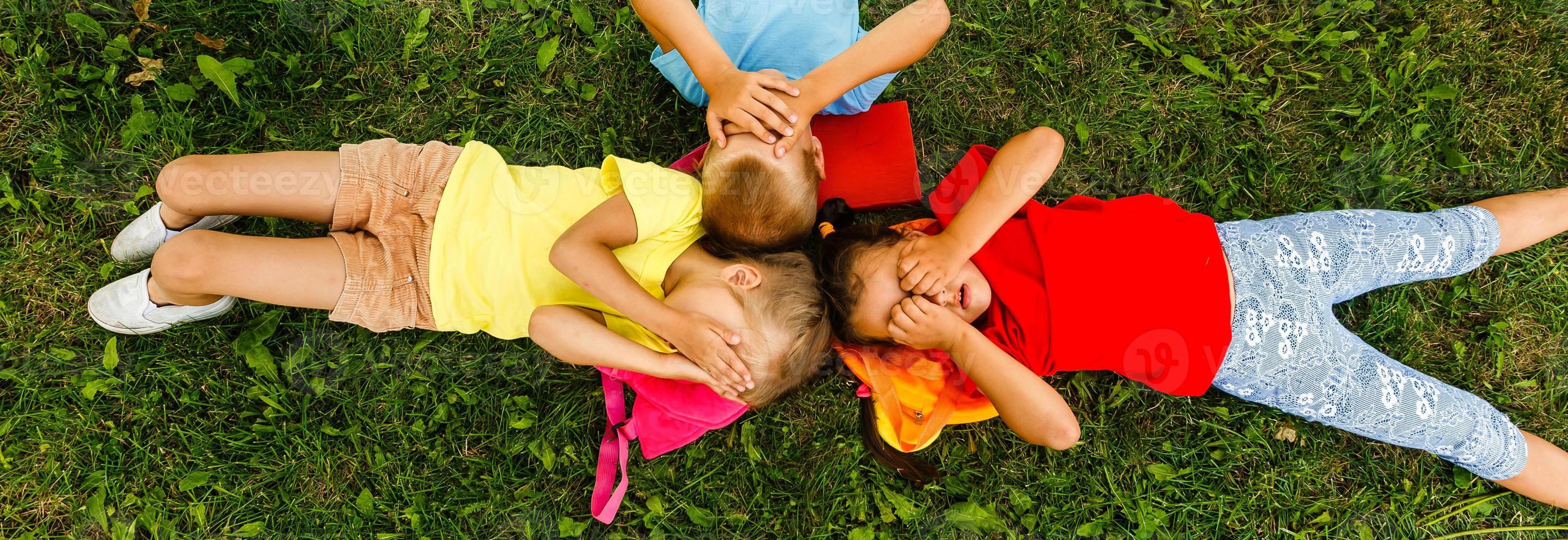 contento niños acostado en césped en parque foto