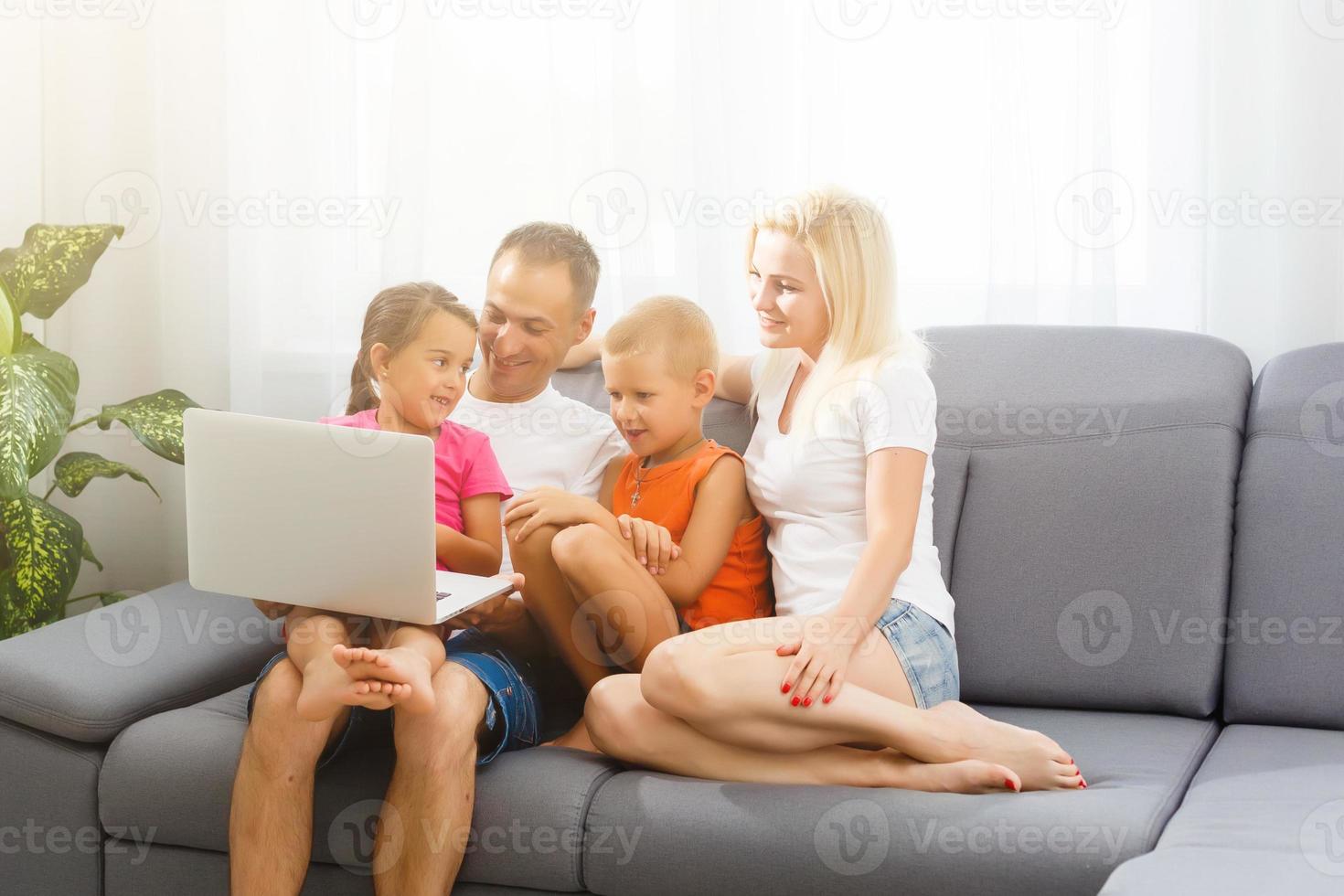 hermosa sonriente multiético familia en frente de el ordenador portátil vídeo llamada con distante padres a hogar. foto