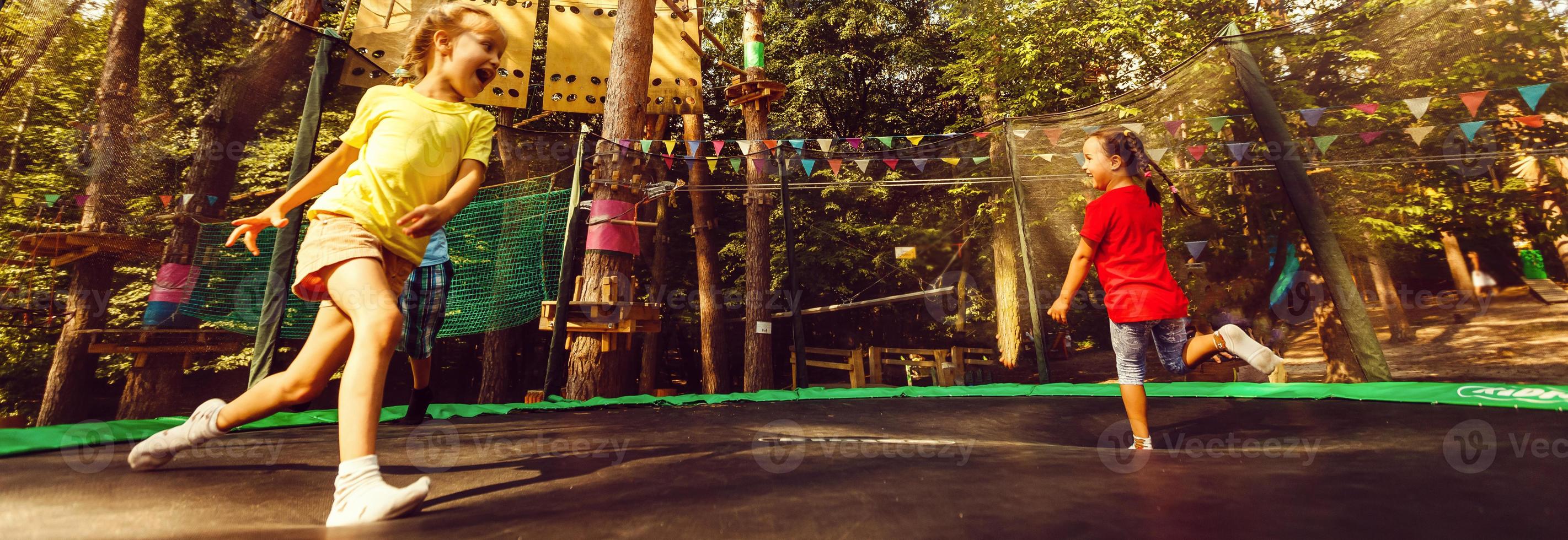 dos dulce niños, hermanos, saltando en un trampolín, Hora de verano, teniendo divertida. activo niños foto