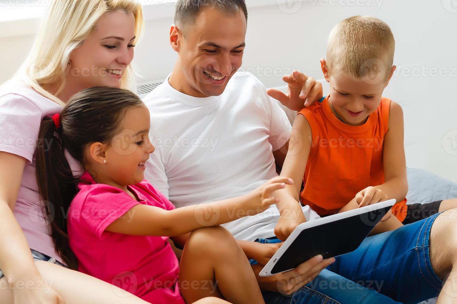 Portrait of happy family with two children sitting on sofa photo