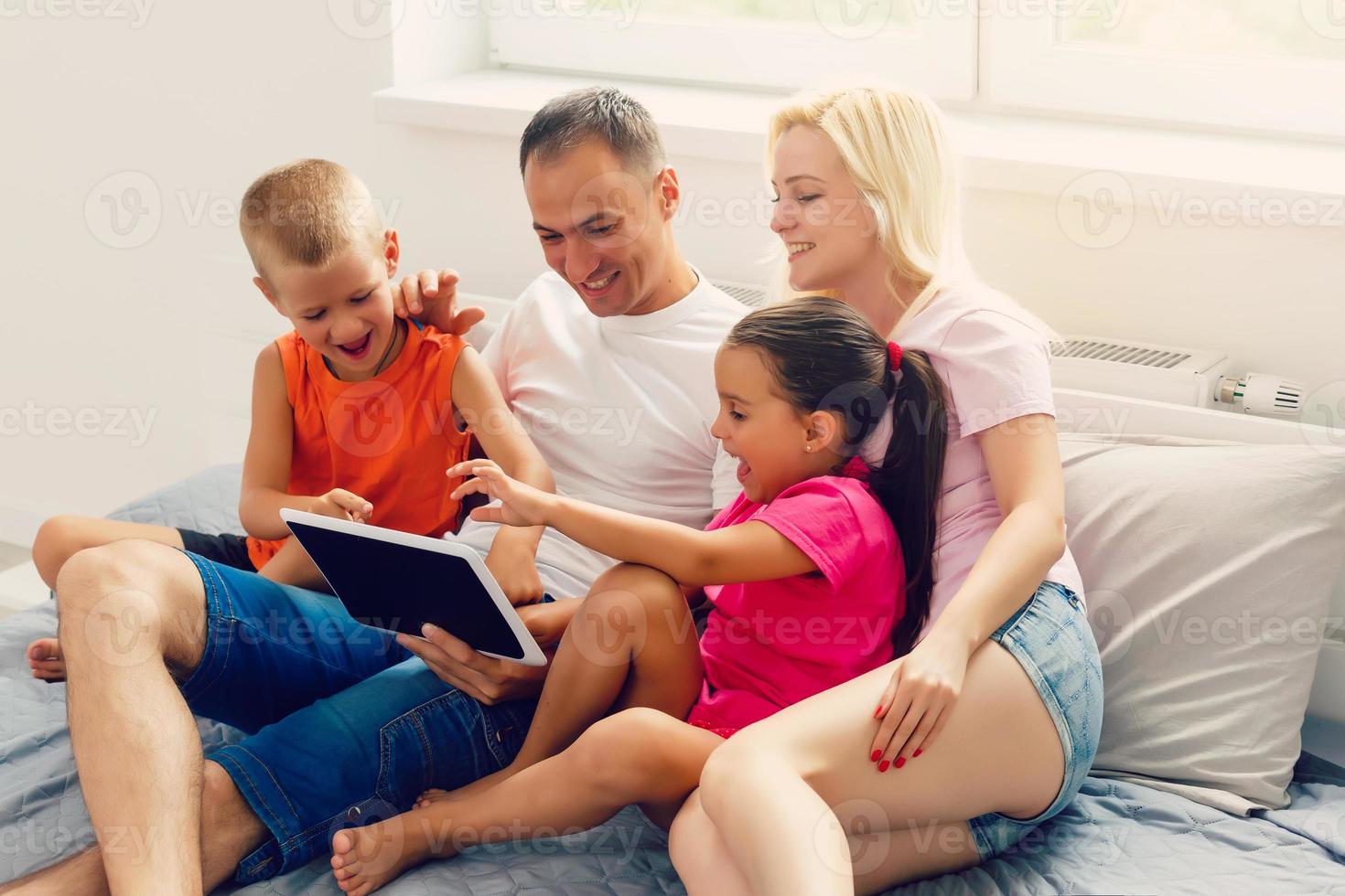 Family looking at laptop and laughing photo