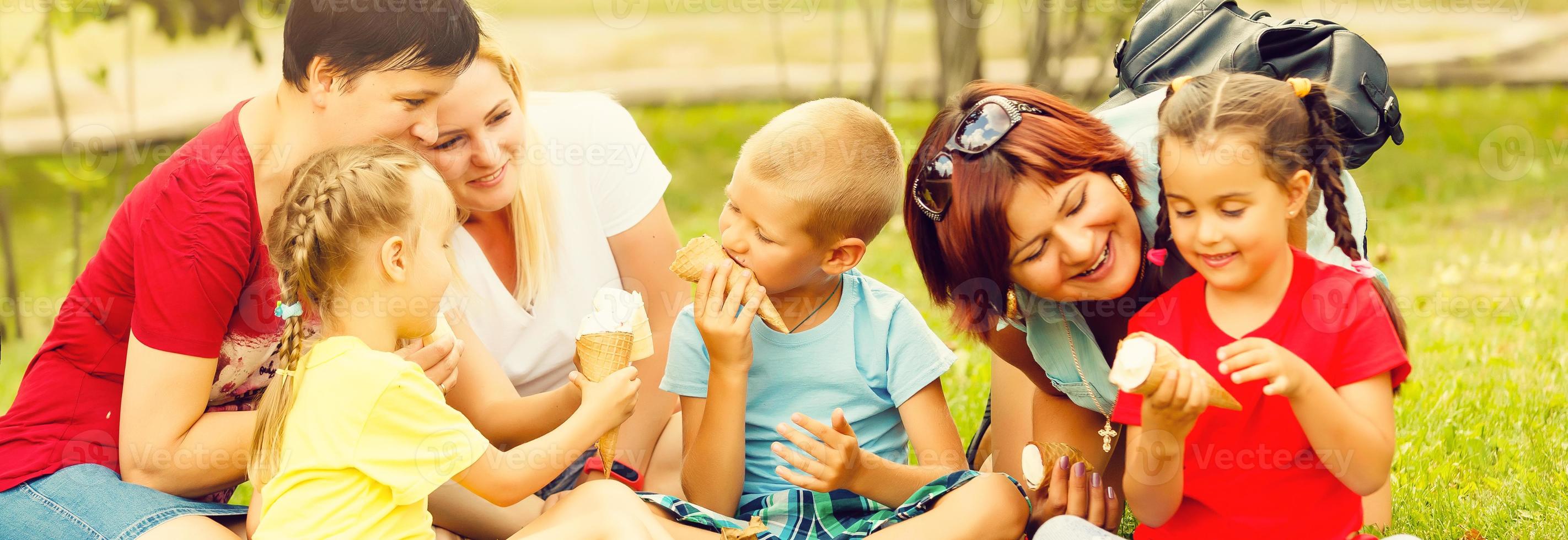 Family with kids eating ice-cream. Outdoor. photo