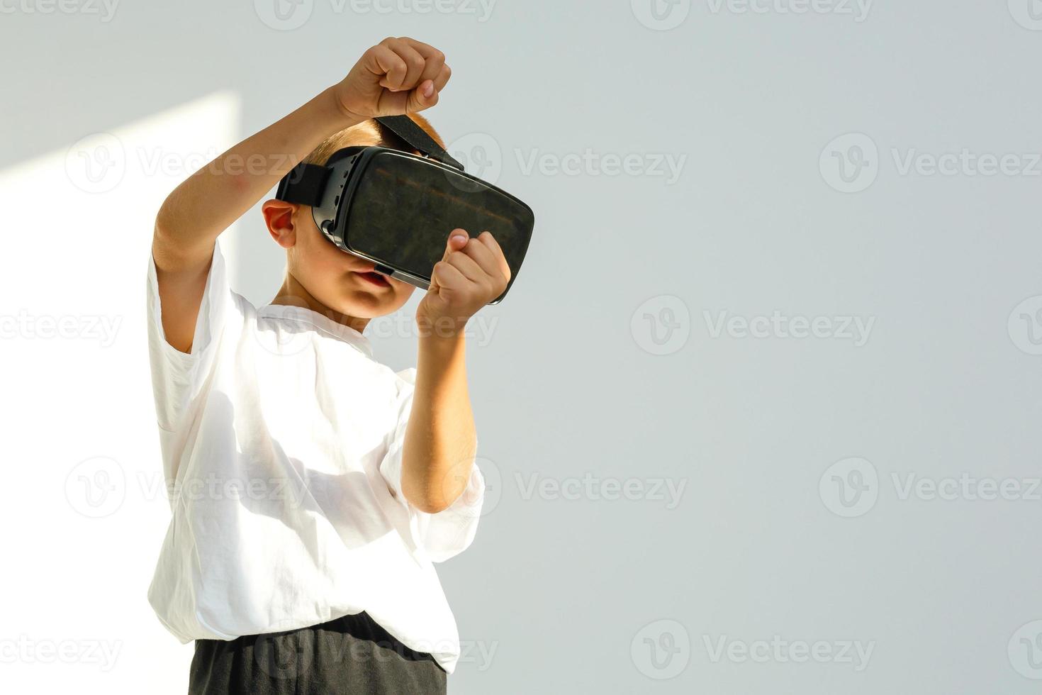 Children experiencing virtual reality isolated on white background. Surprised little boy looking in VR glasses. photo