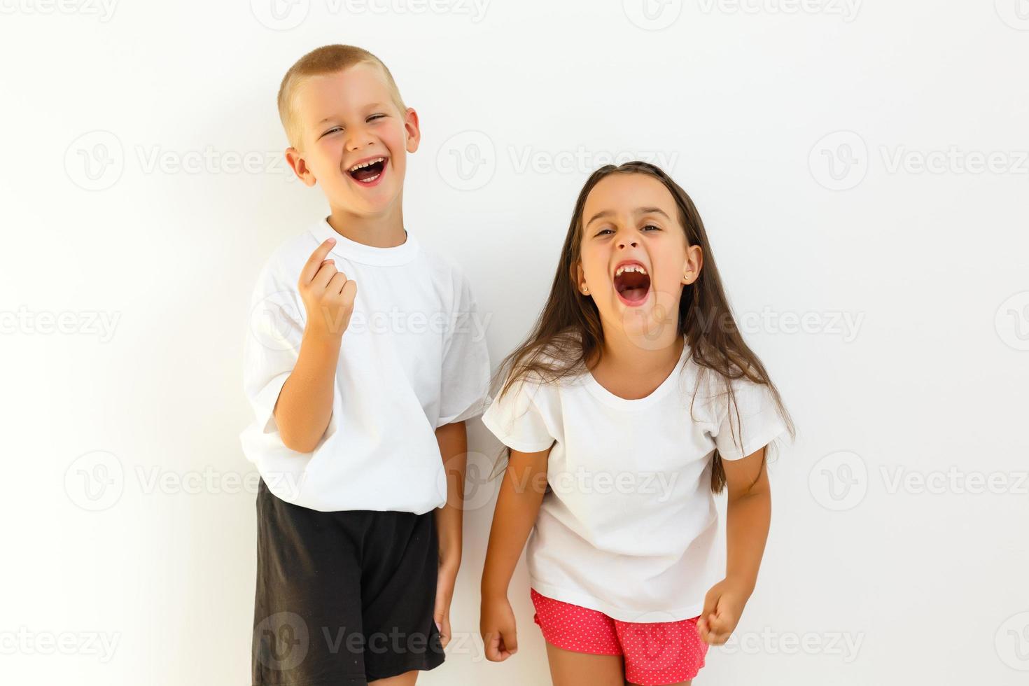 pequeño linda chico niña abrazando jugando en blanco fondo, contento familia cerca arriba aislado. hermano y hermana sonriente foto