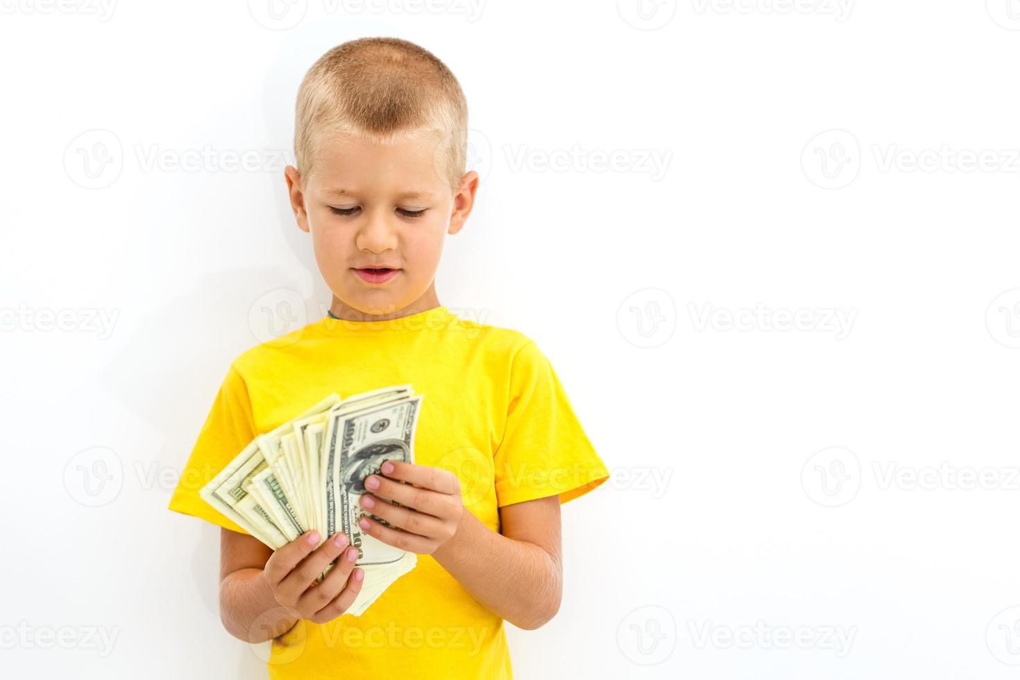 retrato de un alegre pequeño chico participación un dolares terminado blanco antecedentes foto