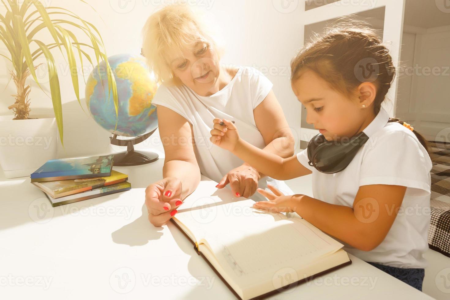 Baby-sitter and little girl doing homework photo
