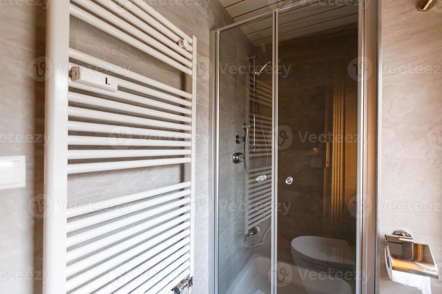 Modern spacious bathroom with bright tiles with toilet and sink. Side view photo