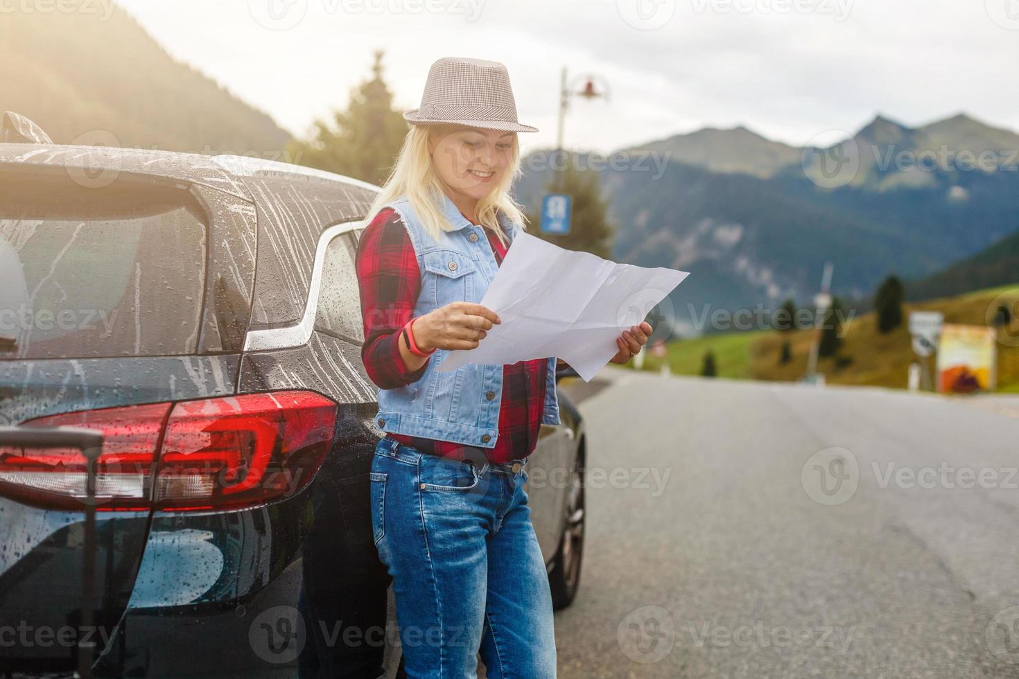 Young woman traveler with a map on the background of the Alps. Active leisure, lifestyle sports, hiking in the mountains. Travelling in Europe. photo