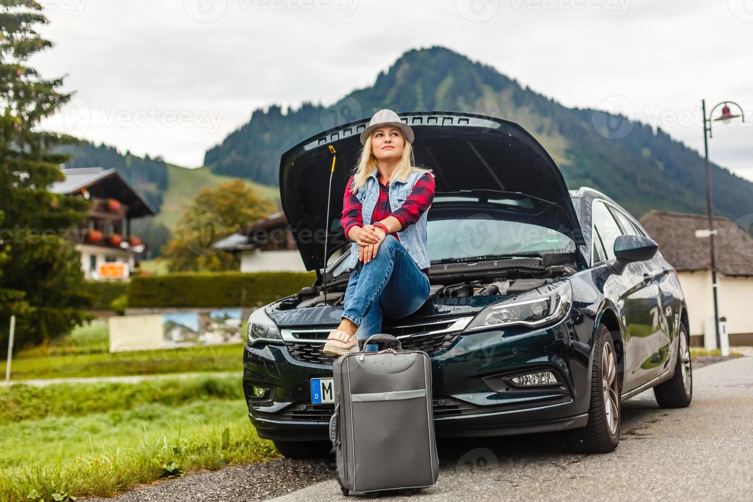 woman in the summer goes on vacation, on vacation with an suitcase on the background of nature and mountains. The concept of travel, weekend in a beautiful place in the mountains photo