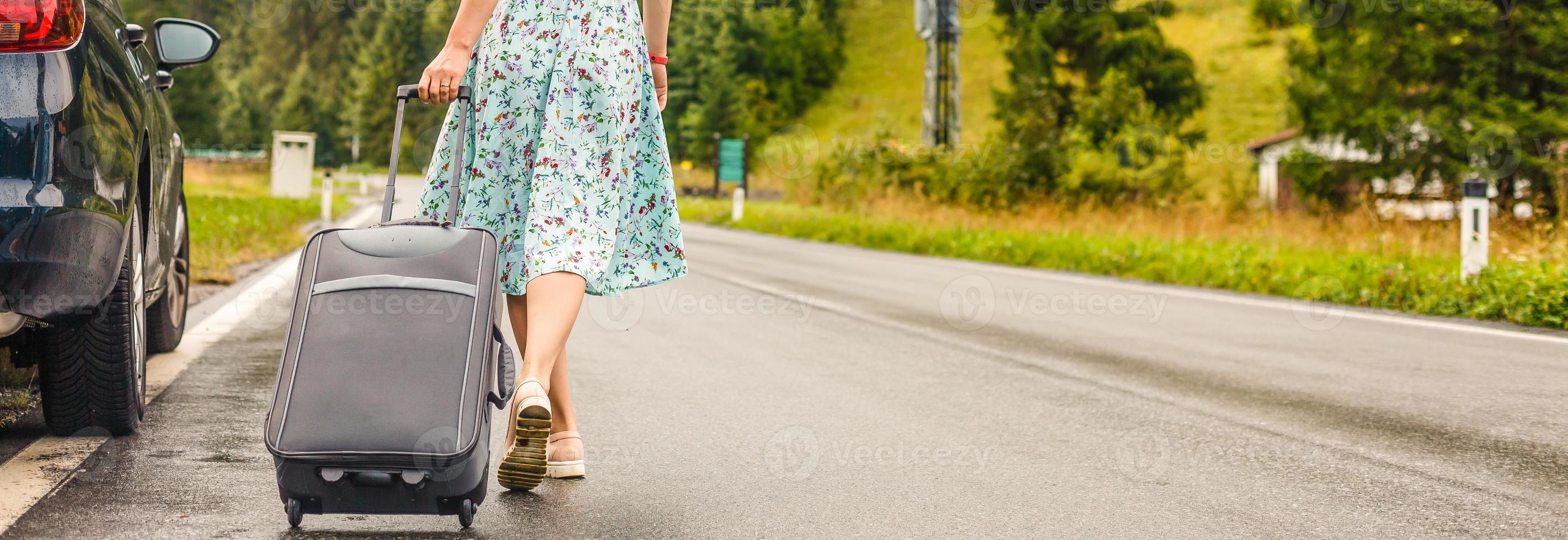 Traveler woman texting a smartphone while is waiting with a suitcase photo