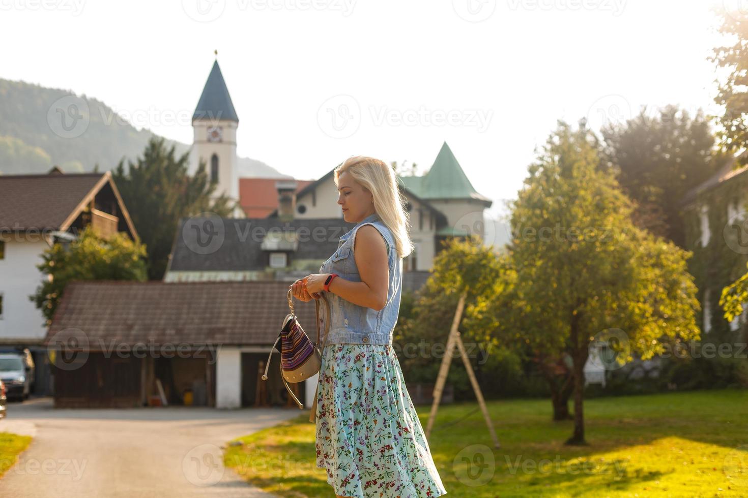 Young woman is standing by wooden houses. village in mountains. Travel, Lifestyle Concept. Alps, Europe. photo