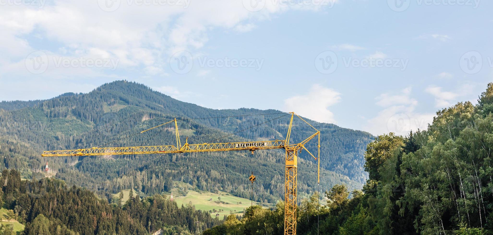 grande torre grua trabajos a un construcción sitio en el montañas, montañas Alpes antecedentes foto