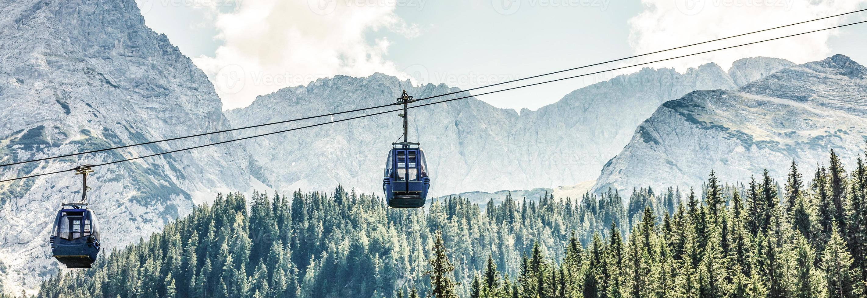 Two cabs of the cableway and skiers on the slope of the mountain Chopok south side on a sunny day in the ski photo