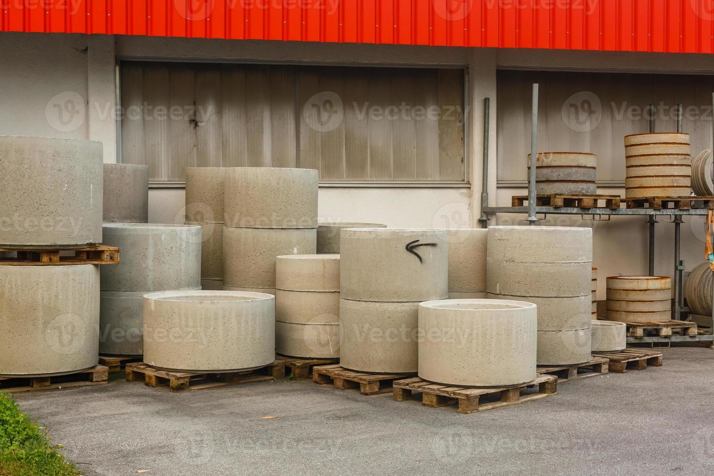 Concrete ring wells with different diameters and gray lie in the street photo