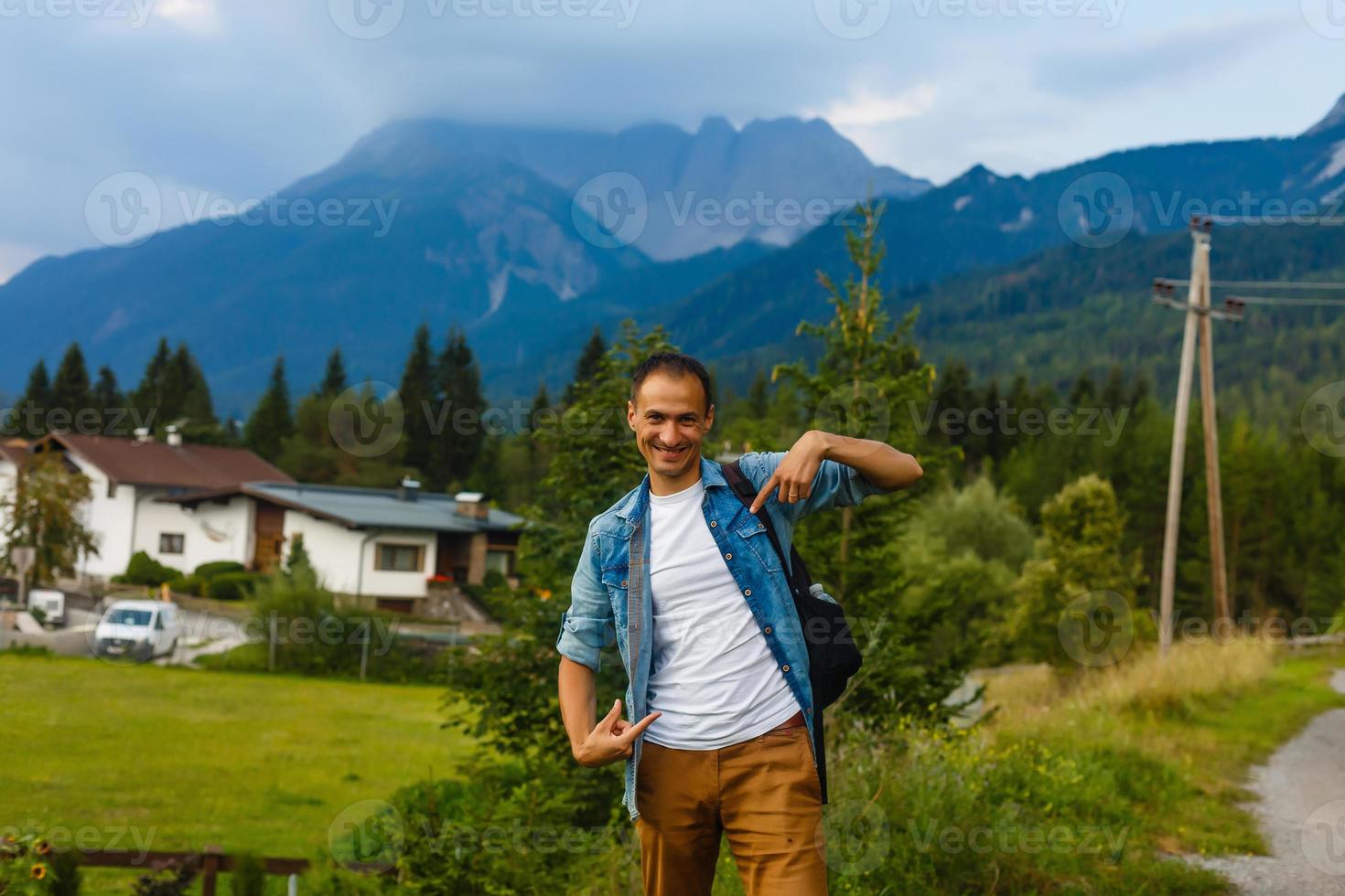 man pointing his fingers at the front of at his blank white t-shirt with copyspace for your text or logo photo