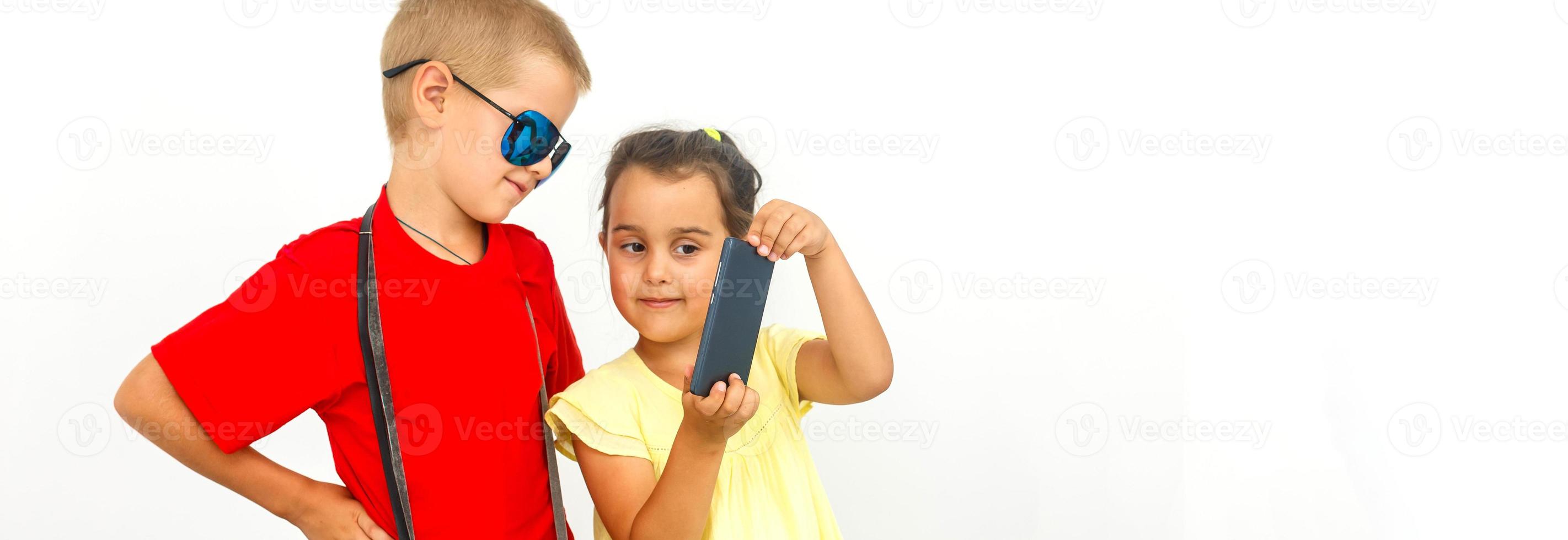 The young traveler brother and sister with a suitcase. Isolated over white background photo