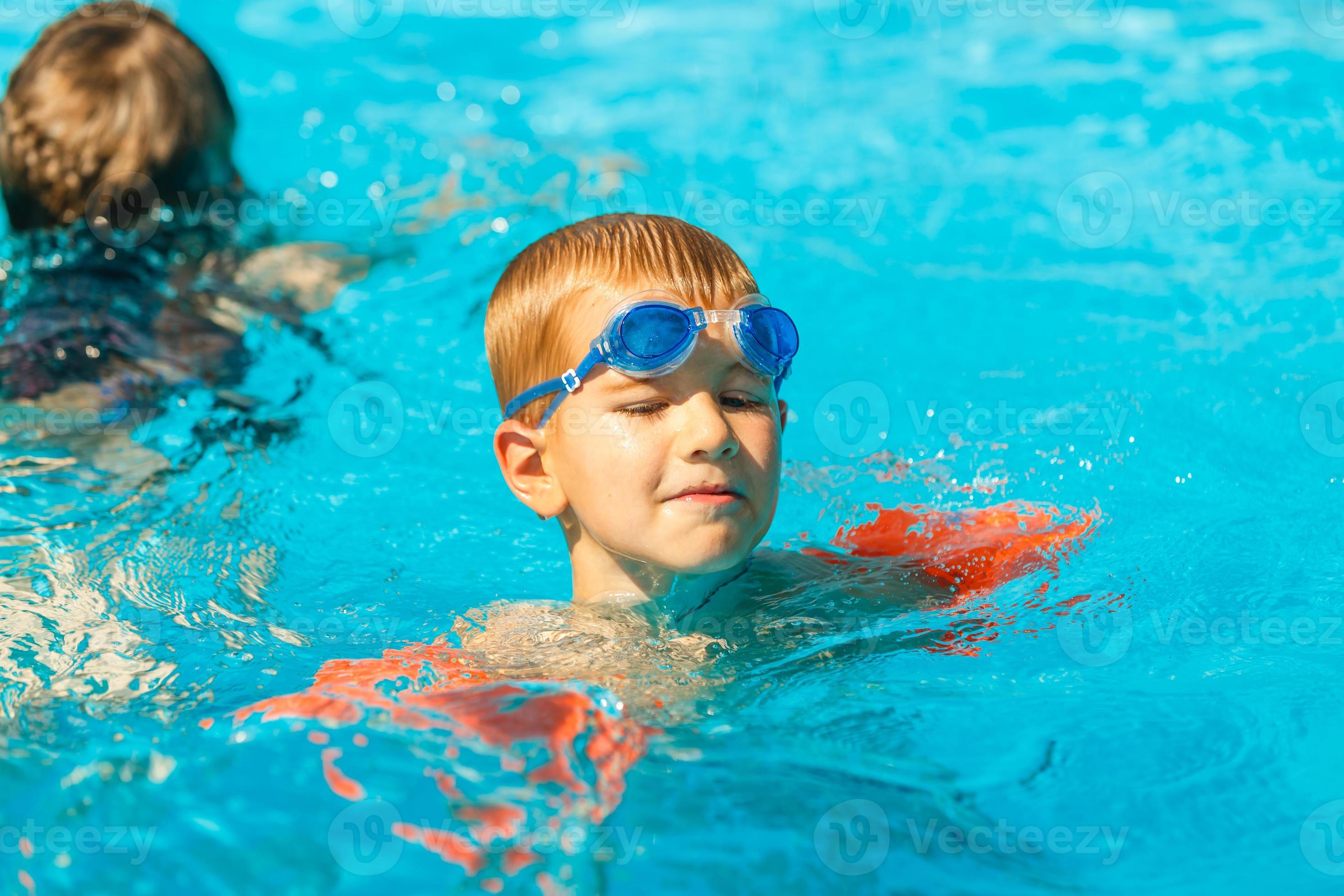 Boy In Armbands And Goggles Learn To Swim In Swimming Pool 20888603