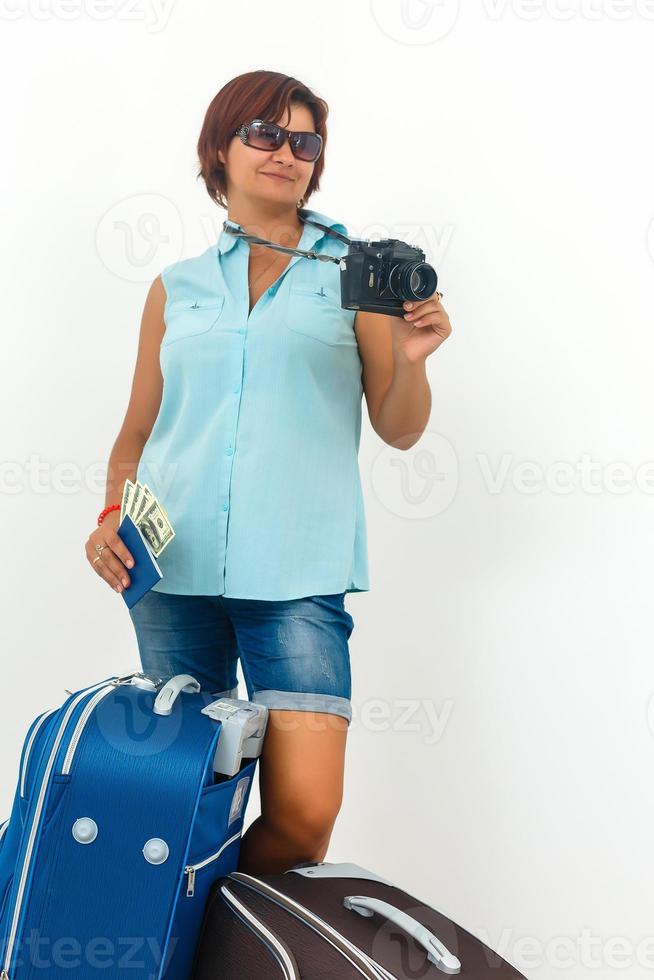 Young woman ready to holiday with camera, paper map and suitcase. photo