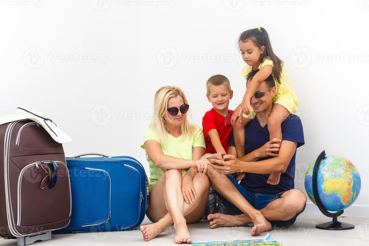 Concept travel and tourism. happy family with suitcases near empty wall photo