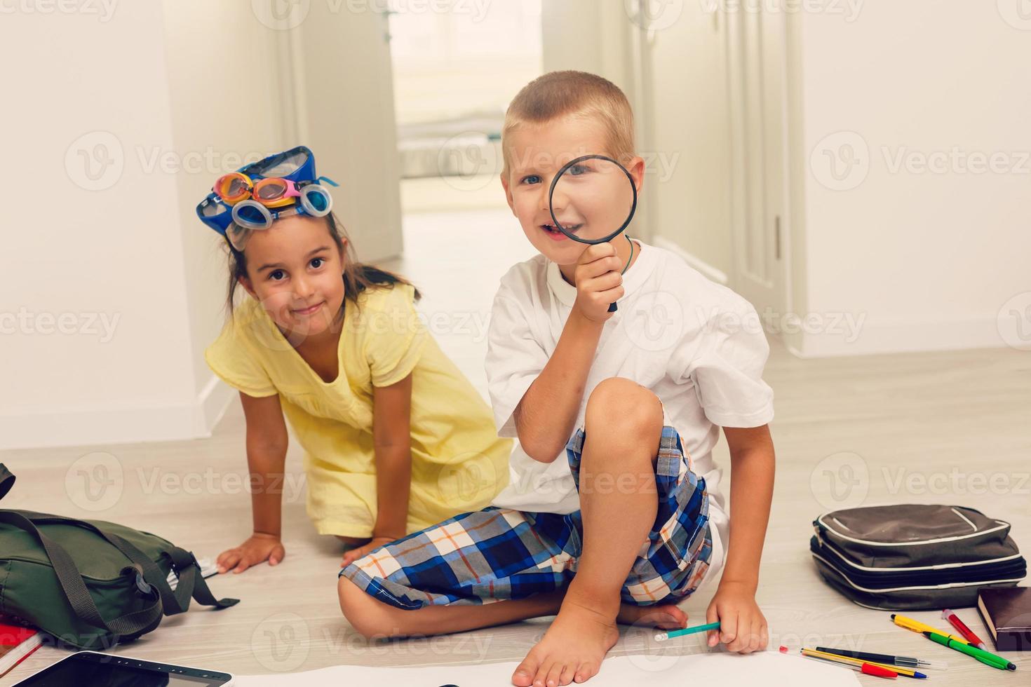 Boy and girl playing with magnifying glass and glasses photo