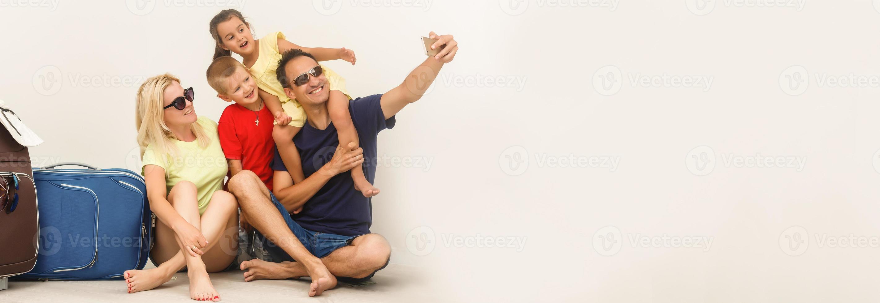 un contento familia con su maletas en un blanco antecedentes foto