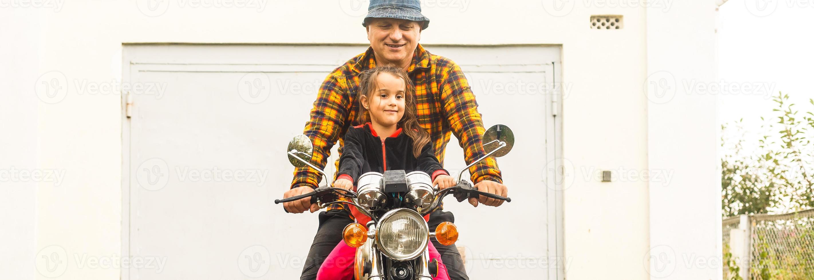 Happy grandfather and his granddaughter in handmade sidecar bike smiling photo