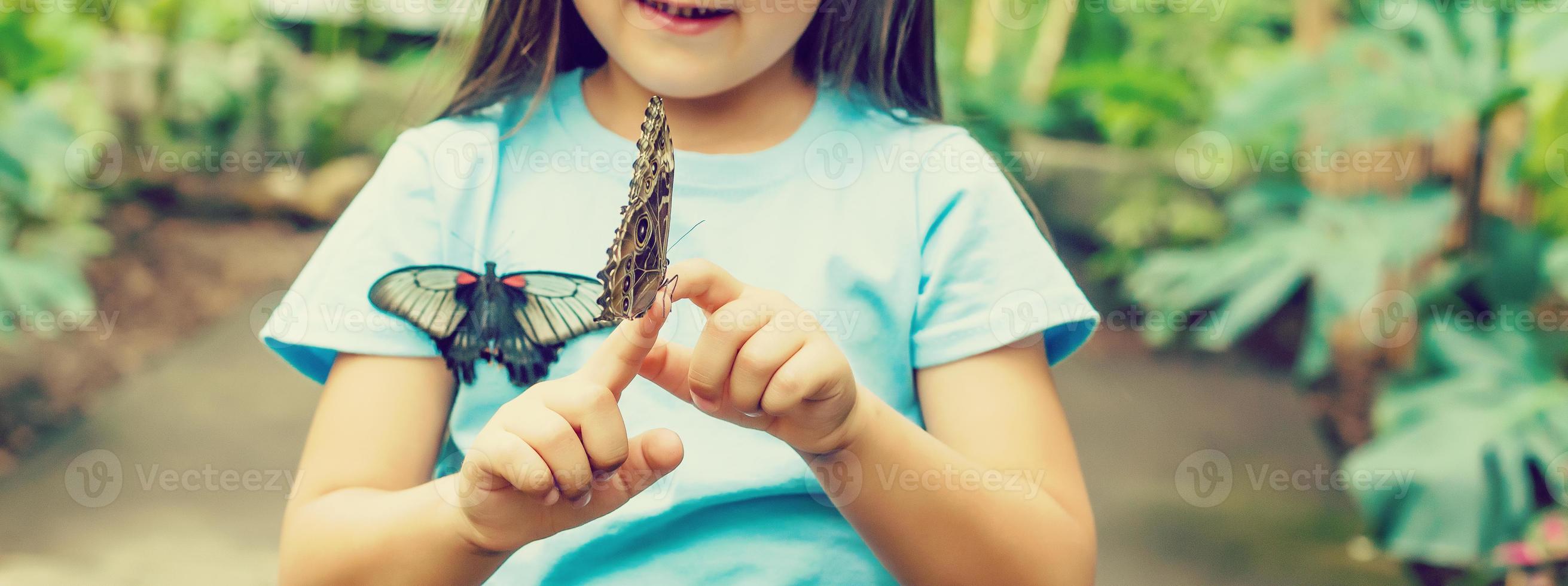 hermosa mariposa sentado en el niña mano foto