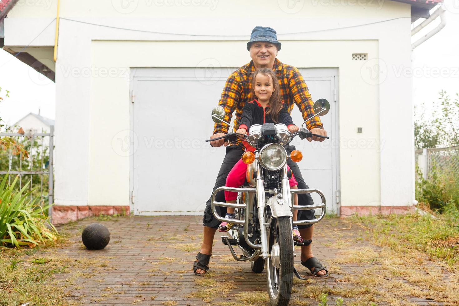 Happy grandfather and his granddaughter in handmade sidecar bike smiling photo