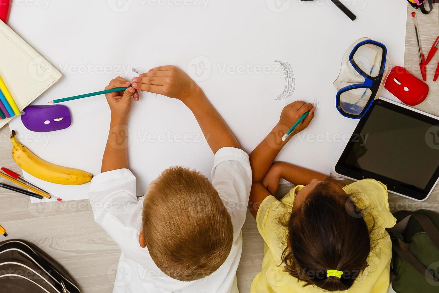 Two children, little girls of preschool age watching tablet at home on the floor photo