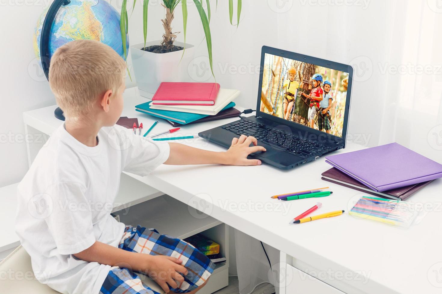 Happy boy sitting With laptop computer photo