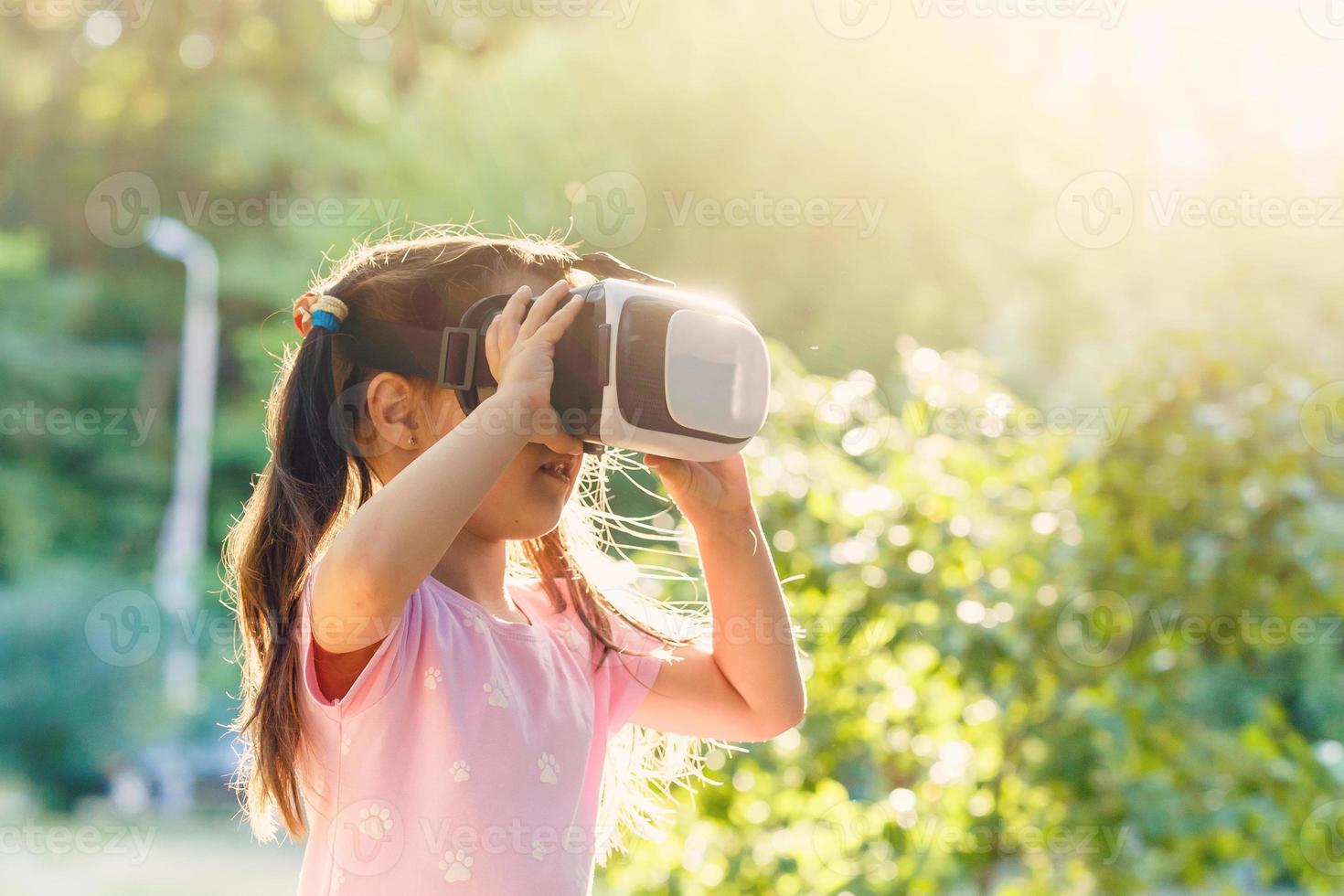 niño con virtual realidad auriculares sentado detrás natrue al aire libre a hogar. foto