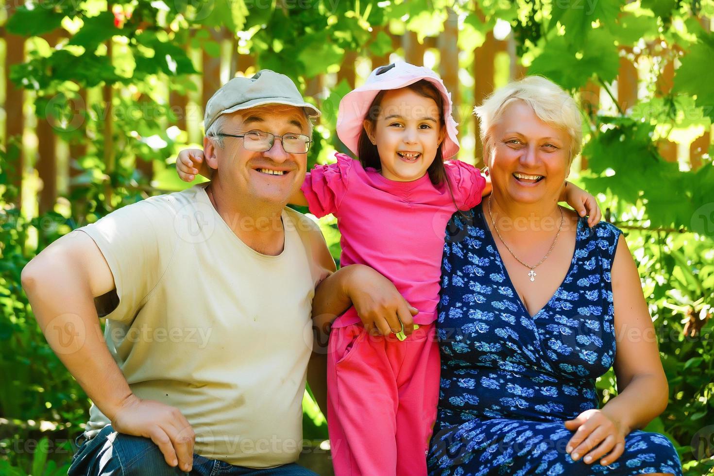 Grandparents with her granddaughter in the park photo