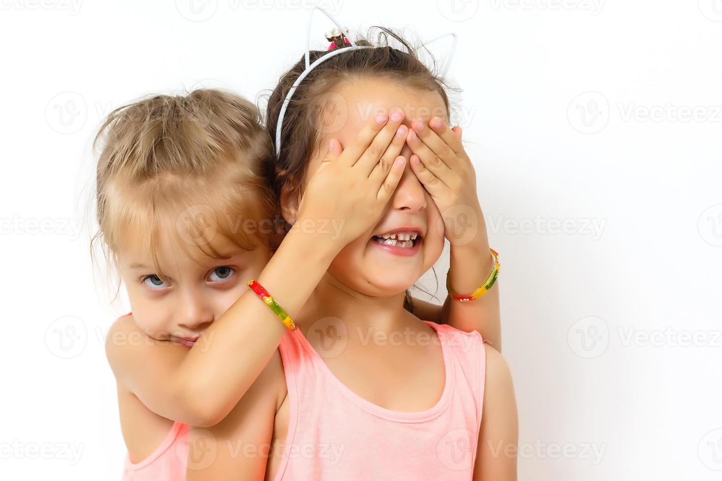 Two happy teenage girls hugging each other isolated on white background photo