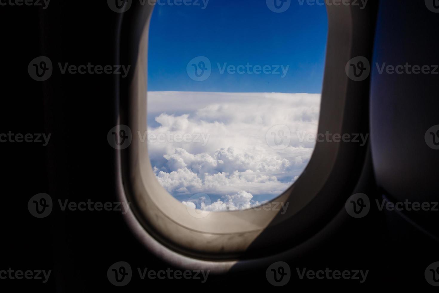 blue sky and cloud with looking out an airplanes porthole window during a flight , image using for sky and interior airplane concept photo