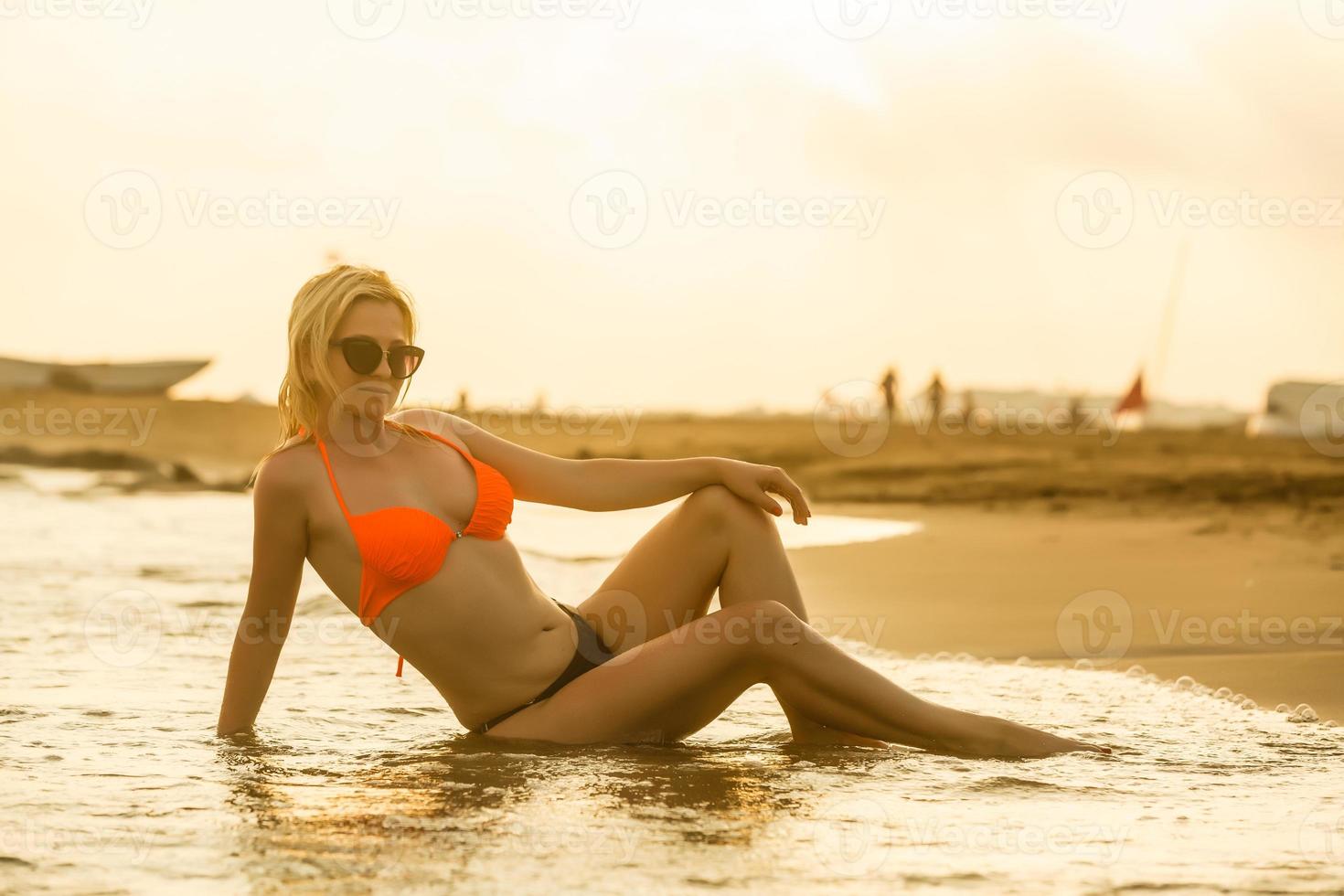 romantic dreams, beautiful girl sitting alone on calm quiet sunset beach, relaxation photo