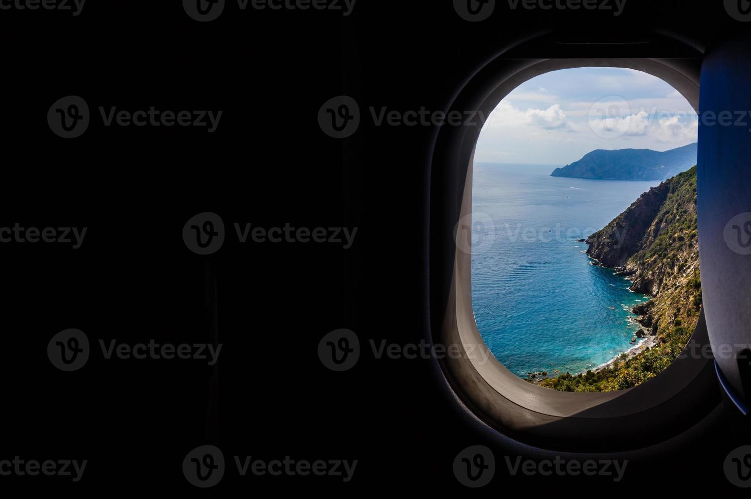 Italy looking out an airplanes porthole window during a flight , image using for sky and interior airplane concept photo
