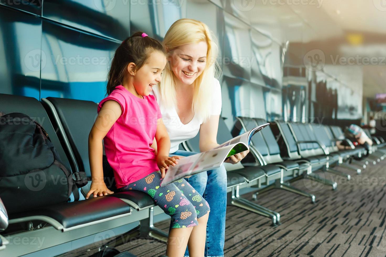 familia en aeropuerto. atractivo joven mujer y linda pequeño hija son Listo para de viaje contento familia concepto. foto