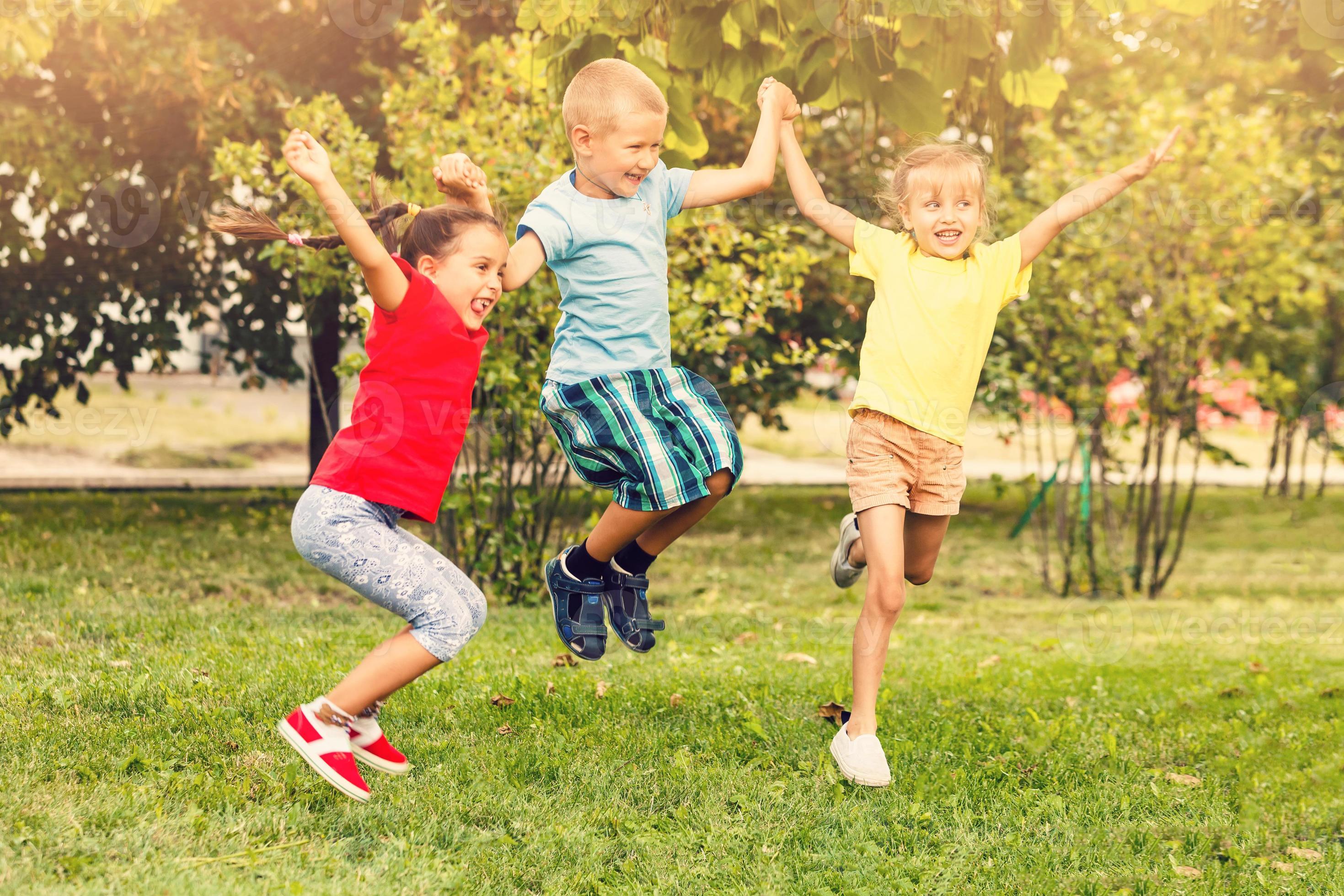 Group of five happy children jumping outdoors., Group of fi…