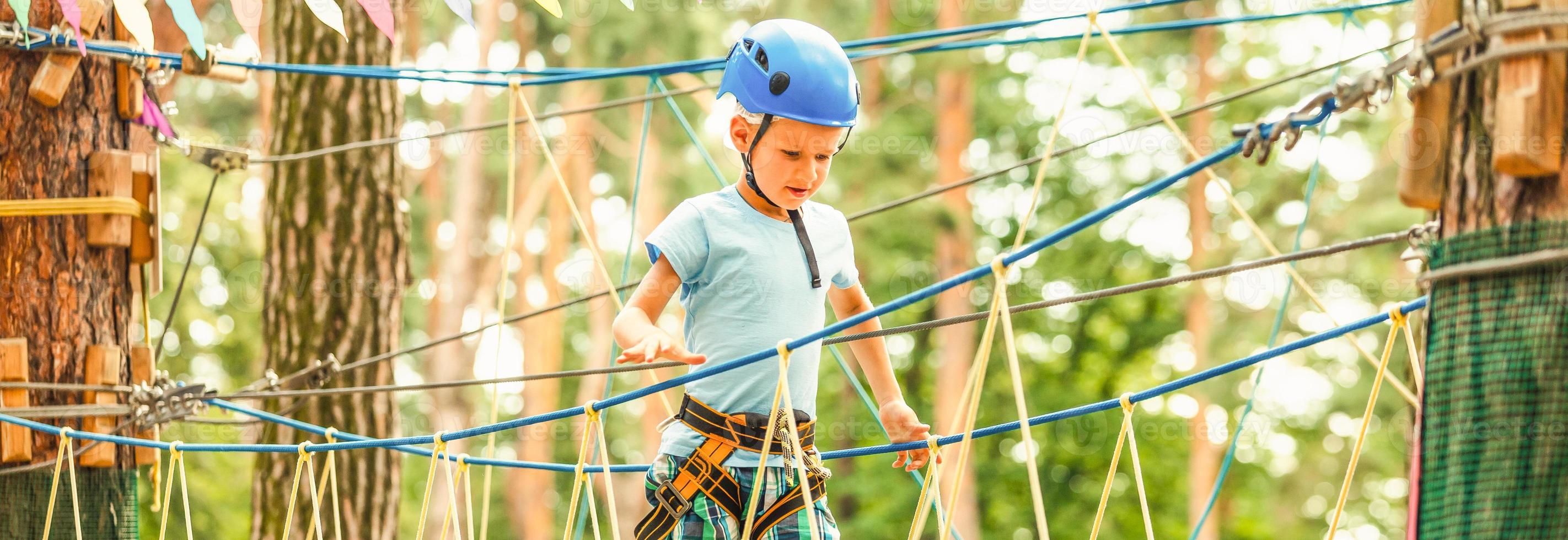 Five year boy on rope-way in forest photo